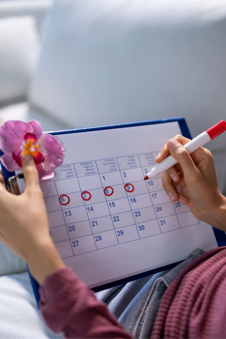 Une femme tient un calendrier du mois dans ses mains